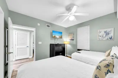 a bedroom with two beds and a ceiling fan at Grandview East 1002 in Panama City Beach