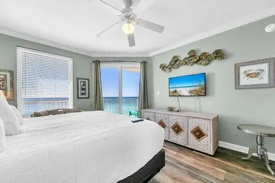 a bedroom with a large white bed and a television at Grandview East 1002 in Panama City Beach