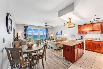 a kitchen and living room with a table and chairs at Laketown Wharf #1219 by Nautical Properties in Panama City Beach