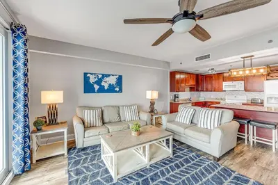 a living room with two couches and a kitchen at Laketown Wharf #1219 by Nautical Properties in Panama City Beach