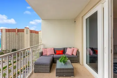 a balcony with a couch and a table at Laketown Wharf #1219 by Nautical Properties in Panama City Beach