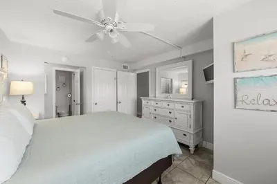 a bedroom with a white bed and a ceiling fan at Summit #1105 by Nautical Properties Vacation Rentals in Panama City Beach