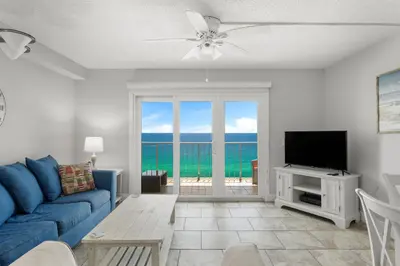 a living room with a blue couch and a tv at Summit #1105 by Nautical Properties Vacation Rentals in Panama City Beach
