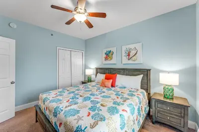 a bedroom with a bed and a ceiling fan at Laketown Wharf #1531 by Nautical Properties in Panama City Beach