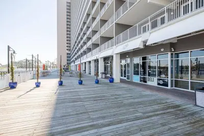 a large building with blue potted plants on a boardwalk at Laketown Wharf #1531 by Nautical Properties in Panama City Beach