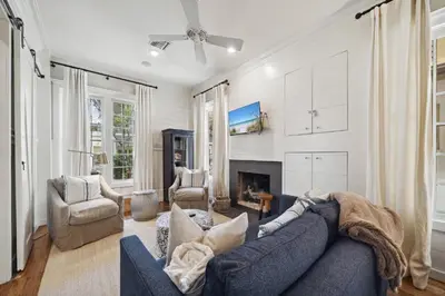 a living room with a blue couch and a fireplace at 67 Wiggle Lane - Rosemary Beach - Steps to Tennis Courts, Beach, Pools! in Rosemary Beach