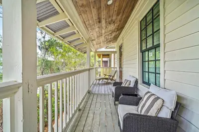a porch of a house with two chairs at 67 Wiggle Lane - Rosemary Beach - Steps to Tennis Courts, Beach, Pools! in Rosemary Beach