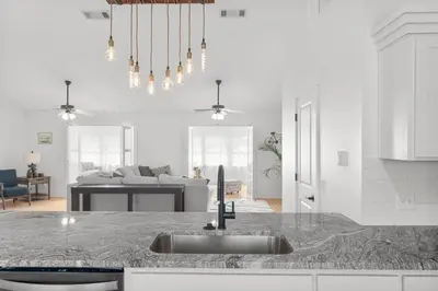 a kitchen with a sink and a living room at Casa de Tortugas - a spacious townhome with 30a private beach access in Seacrest