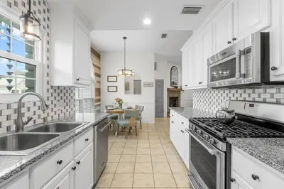 a kitchen with white cabinets and a sink and a stove at Making Memories in Panama City Beach
