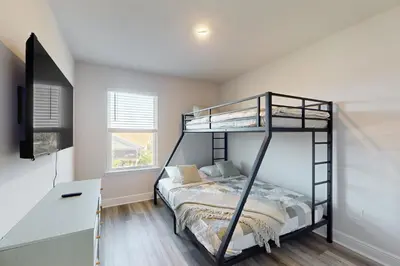 a bedroom with a bunk bed and a desk at Steps to Sand and Surf! Family-Friendly PCB Retreat in Panama City Beach