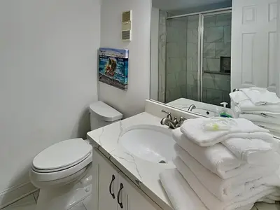 a bathroom with a toilet and a sink with towels at Mariner East #602 in Panama City Beach