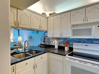 a kitchen with white cabinets and a sink at Mariner East #602 in Panama City Beach