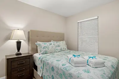 a bedroom with a bed with towels on it at Spacious 4-Bed, 3-Bath Beach House – Sleeps 12 for the Perfect Getaway in Panama City Beach