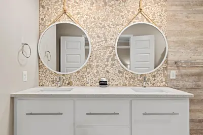 a bathroom with two sinks and two mirrors at Spacious 4-Bed, 3-Bath Beach House – Sleeps 12 for the Perfect Getaway in Panama City Beach