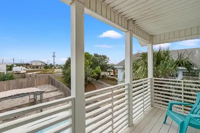 a porch with a blue chair and a table at Spacious 4-Bed, 3-Bath Beach House – Sleeps 12 for the Perfect Getaway in Panama City Beach
