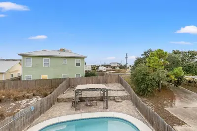 a backyard with a swimming pool and a table at Spacious 4-Bed, 3-Bath Beach House – Sleeps 12 for the Perfect Getaway in Panama City Beach