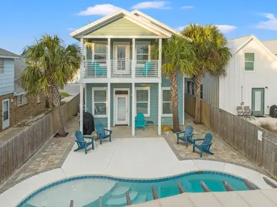 a villa with a swimming pool in front of a house at Spacious 4-Bed, 3-Bath Beach House – Sleeps 12 for the Perfect Getaway in Panama City Beach