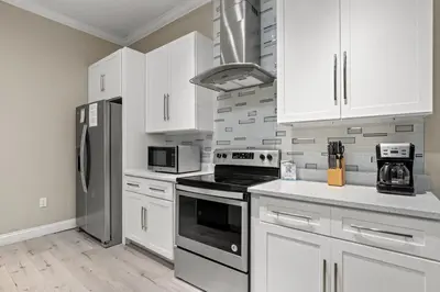 a kitchen with white cabinets and stainless steel appliances at Spacious 4-Bed, 3-Bath Beach House – Sleeps 12 for the Perfect Getaway in Panama City Beach