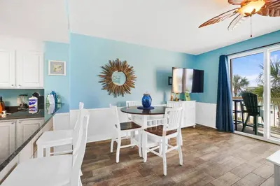 a kitchen and dining room with a table and chairs at Calypso 203 1 Bedroom Gulf Front in Panama City Beach