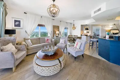 a living room with a couch and a table at Calypso 2109 West Corner Unit with incredible gulf views for miles in Panama City Beach