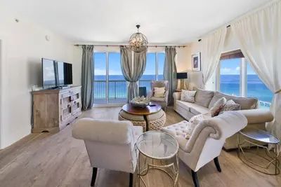 a living room with a couch and chairs and a tv at Calypso 2109 West Corner Unit with incredible gulf views for miles in Panama City Beach