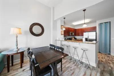 a kitchen and dining room with a wooden table at Aqua 110 New Remodel Ground Level, The most Requested Unit in Building in Panama City Beach