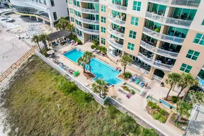 an aerial view of a swimming pool in front of a building at Aqua 110 New Remodel Ground Level, The most Requested Unit in Building in Panama City Beach