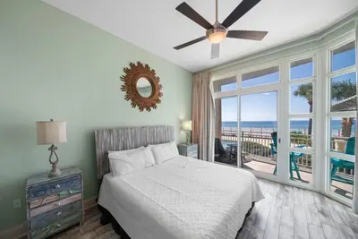 a bedroom with a bed and a view of the ocean at Aqua 110 New Remodel Ground Level, The most Requested Unit in Building in Panama City Beach