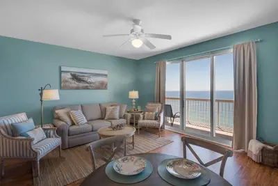 a living room with a view of the ocean at 2007 Calypso East 1 Bedroom in Panama City Beach