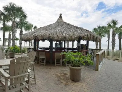 a restaurant with a straw hut on the beach at 2007 Calypso East 1 Bedroom in Panama City Beach