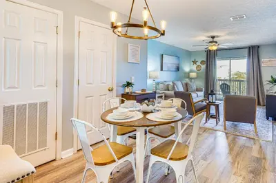 a dining room and living room with a table and chairs at Walk to Beach Condo with Balcony in PCB! in Panama City Beach