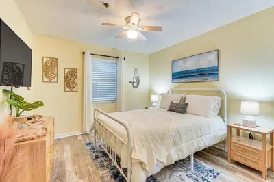 a bedroom with a bed and a ceiling fan at Walk to Beach Condo with Balcony in PCB! in Panama City Beach