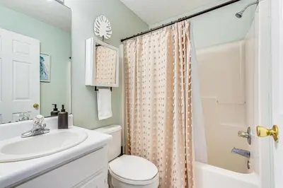 a bathroom with a sink and a toilet and a shower at Walk to Beach Condo with Balcony in PCB! in Panama City Beach