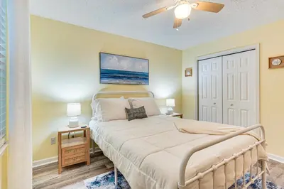 a bedroom with a bed and a ceiling fan at Walk to Beach Condo with Balcony in PCB! in Panama City Beach