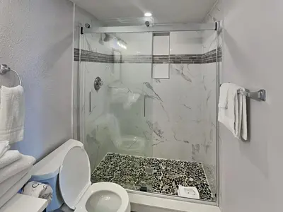 a bathroom with a glass shower with a toilet at Edgewater Tower II 2 in Panama City Beach