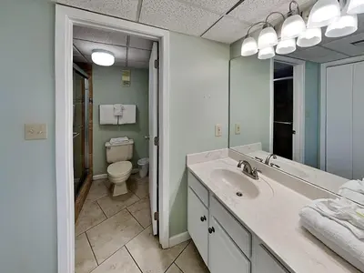 a bathroom with a sink and a toilet and a mirror at Edgewater Tower II 2 in Panama City Beach
