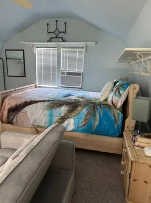 a bedroom with a bed and a window and a chair at Beachy Bungalow, Santa Rosa Beach, FL near Gulf in Santa Rosa Beach