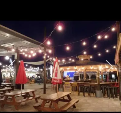 a patio with picnic tables and chairs and lights at Beachy Bungalow, Santa Rosa Beach, FL near Gulf in Santa Rosa Beach