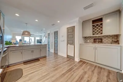 a large kitchen with white cabinets and a wooden floor at Dreamscape 30! Luxury Beach Front Property! in Panama City Beach