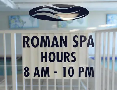 a sign that reads roman spam hours am pm at Tidewater 1003 in Panama City Beach