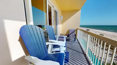 a balcony with blue chairs and the beach at Calypso I 407E in Panama City Beach