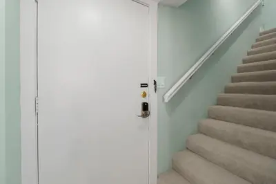 a stairway with a door leading up to a set of stairs at Fabulous 3-Bed 3-Bath Condo with Private Covered Parking Space! in Panama City Beach