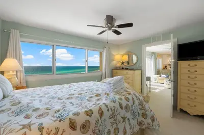 a bedroom with a bed with a view of the ocean at Fabulous 3-Bed 3-Bath Condo with Private Covered Parking Space! in Panama City Beach