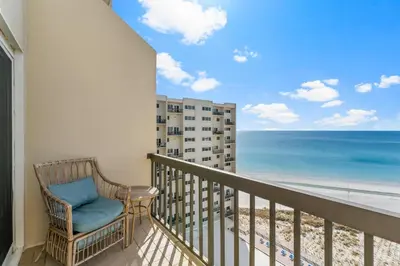 a balcony with a chair and a view of the beach at Beautiful Gulf and Lake views from Pinnacle Port A-935! in Panama City Beach