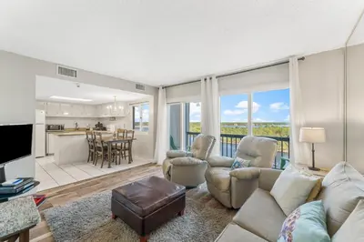 a living room with a couch and chairs and a kitchen at Beautiful Gulf and Lake views from Pinnacle Port A-935! in Panama City Beach