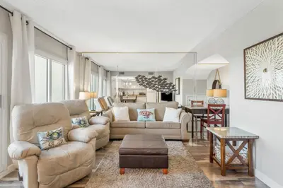 a living room with a couch and a table at Beautiful Gulf and Lake views from Pinnacle Port A-935! in Panama City Beach