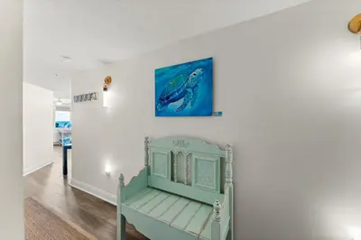 a blue chair in a room with a painting on the wall at Treasure Island #2112 in Panama City Beach