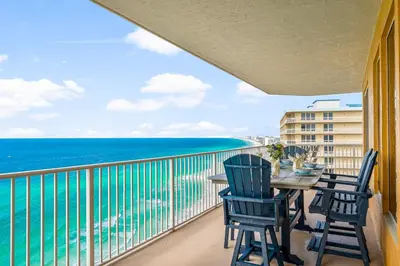 a balcony with a table and chairs and the ocean at Treasure Island #2112 in Panama City Beach