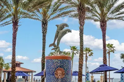 a statue of a bird sitting on top of a pot with palm trees at Shores Of Panama #1224 in Panama City Beach