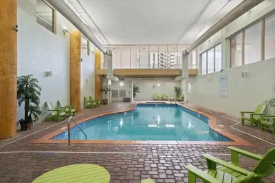 a large swimming pool in a building with green chairs at Shores Of Panama #1224 in Panama City Beach